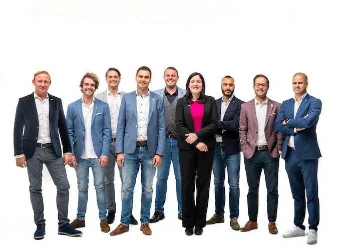 Nine members of the JCI Limburg Matched team standing together, eight men and one woman in smart casual clothes
