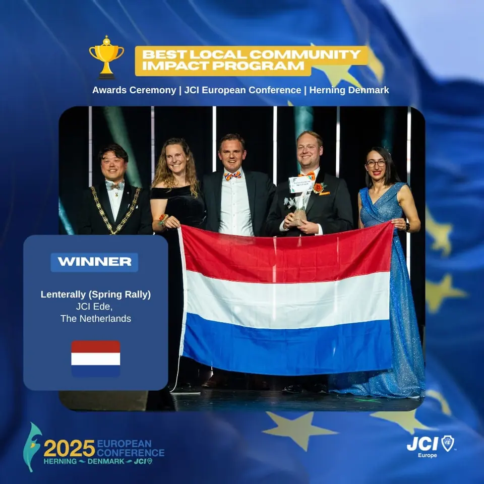 Winners card for Best Local Community Impact Program: Lenterally (Spring Rally) by JCI Ede, The Netherlands, on stage with the Dutch flag