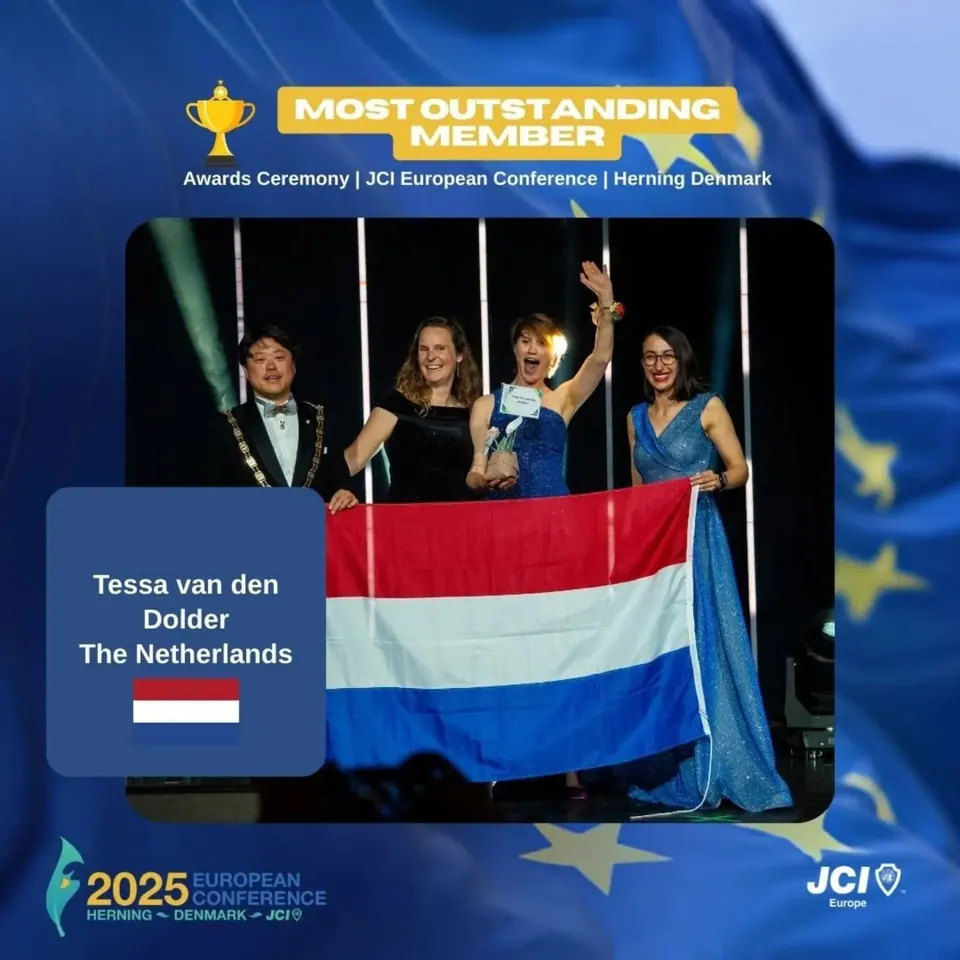 Winners card for Most Outstanding Member: Tessa van den Dolder, The Netherlands, on stage with the Dutch flag