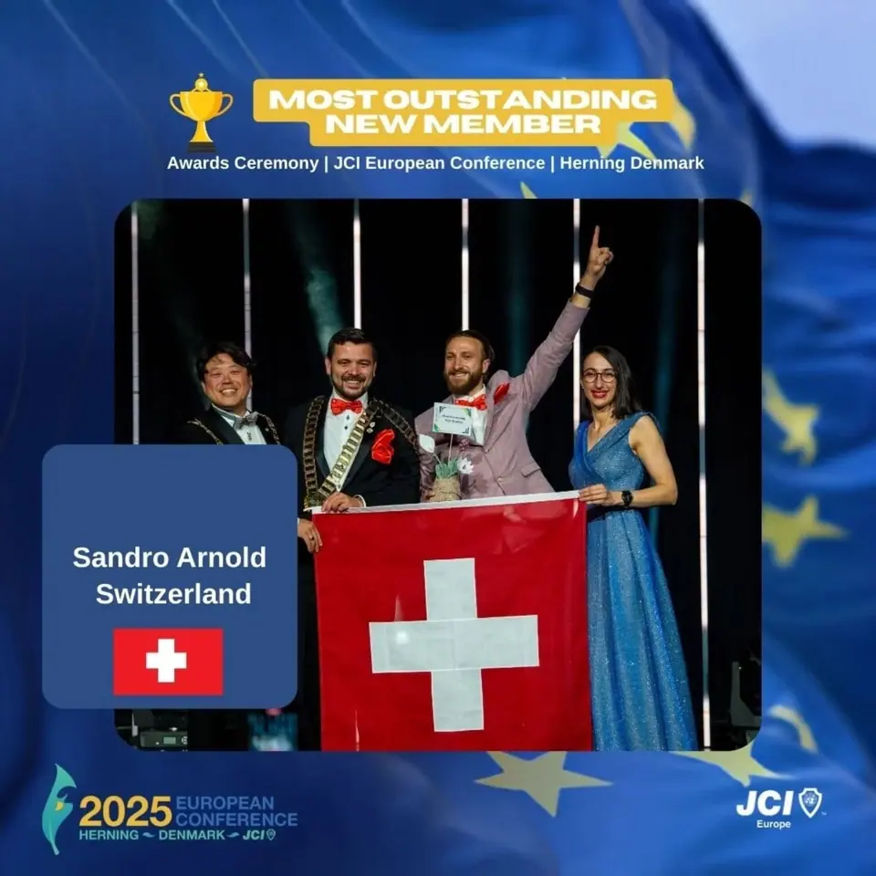Winners card for Most Outstanding New Member: Sandro Arnold, Switzerland, on stage with the Swiss flag