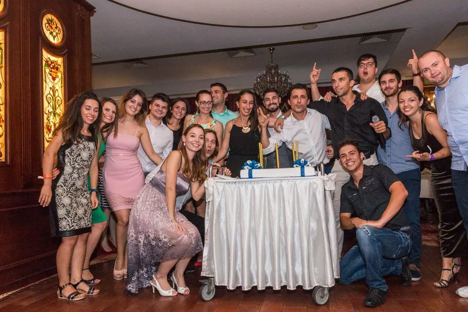 JCI Bulgaria members in party clothes around a birthday table