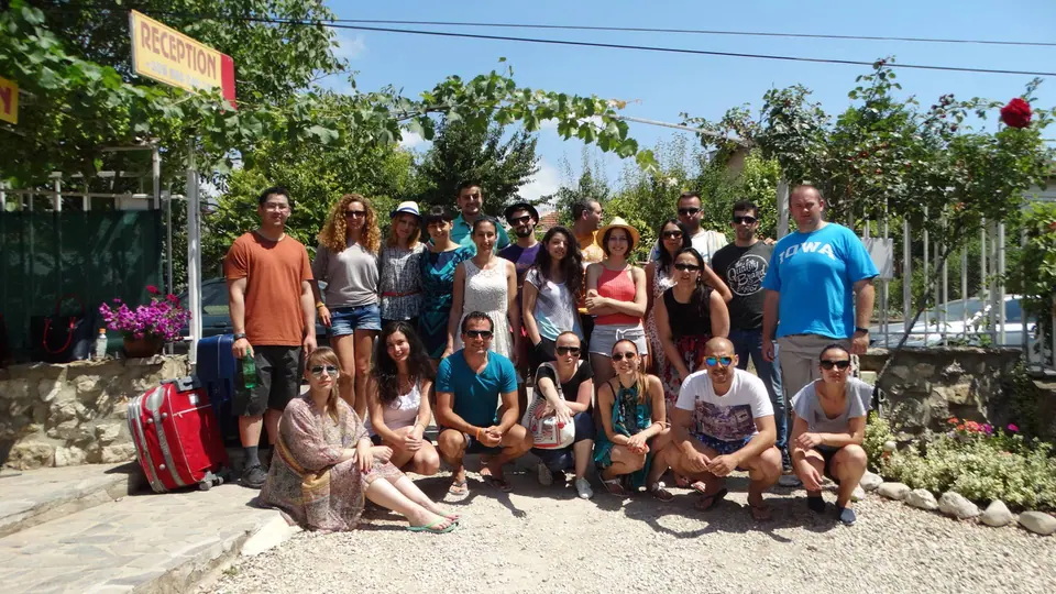 A large group sitting on a garden path during a JCI Bulgaria team-building weekend