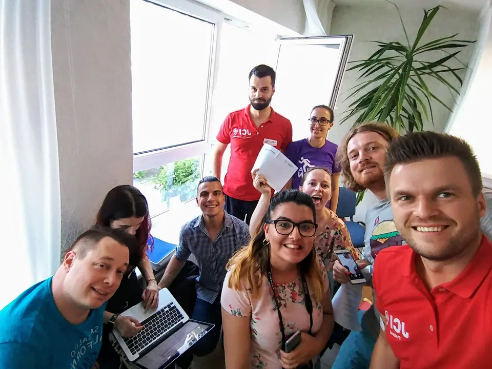 Participants of the Growth and Development Academy taking a group selfie around a laptop