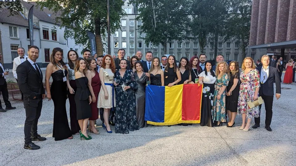 A large group in evening wear holding a Romanian flag in a city square