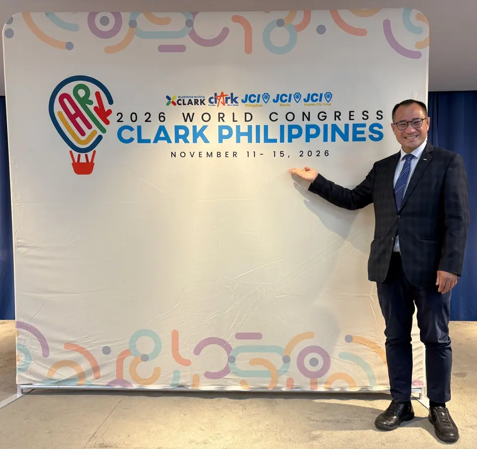 Kevin Hin standing next to a 2026 World Congress Clark Philippines backdrop