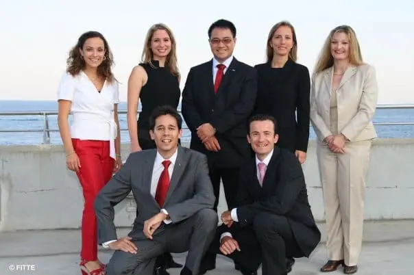 Seven members of a national board posing on a seaside terrace