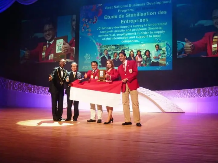 Award winners holding an Indonesian flag on stage at the 2010 World Congress in Osaka