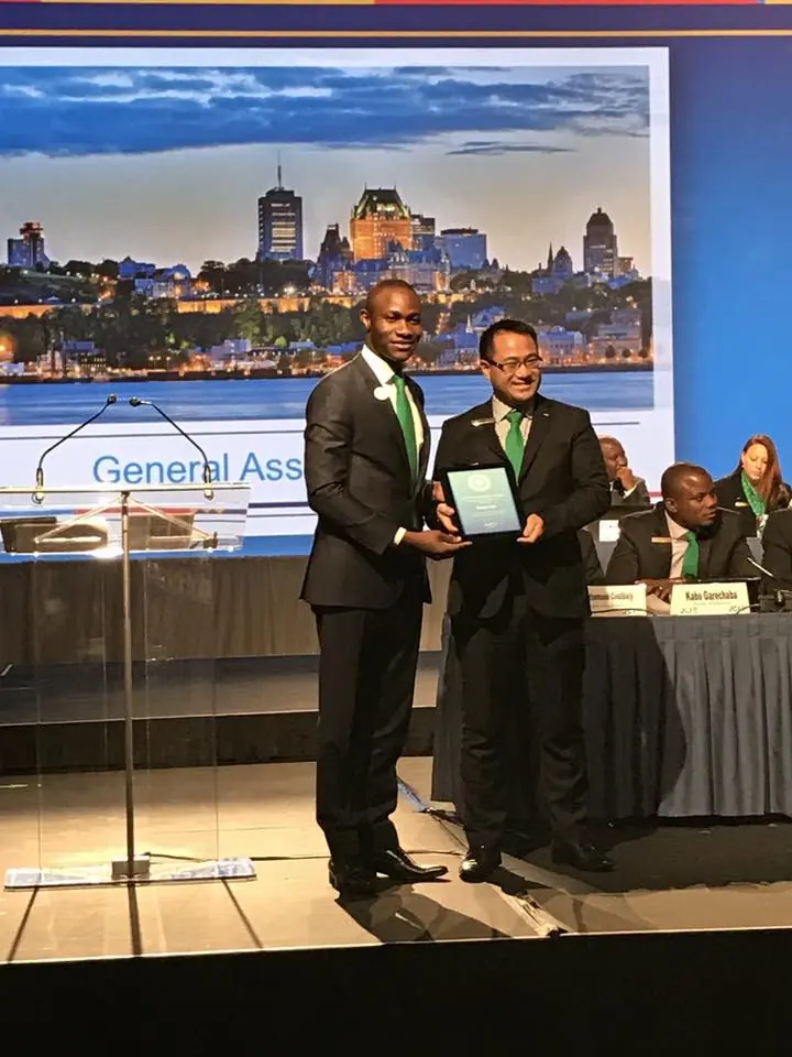 A man in a suit receiving a framed award on stage at the 2016 World Congress in Quebec