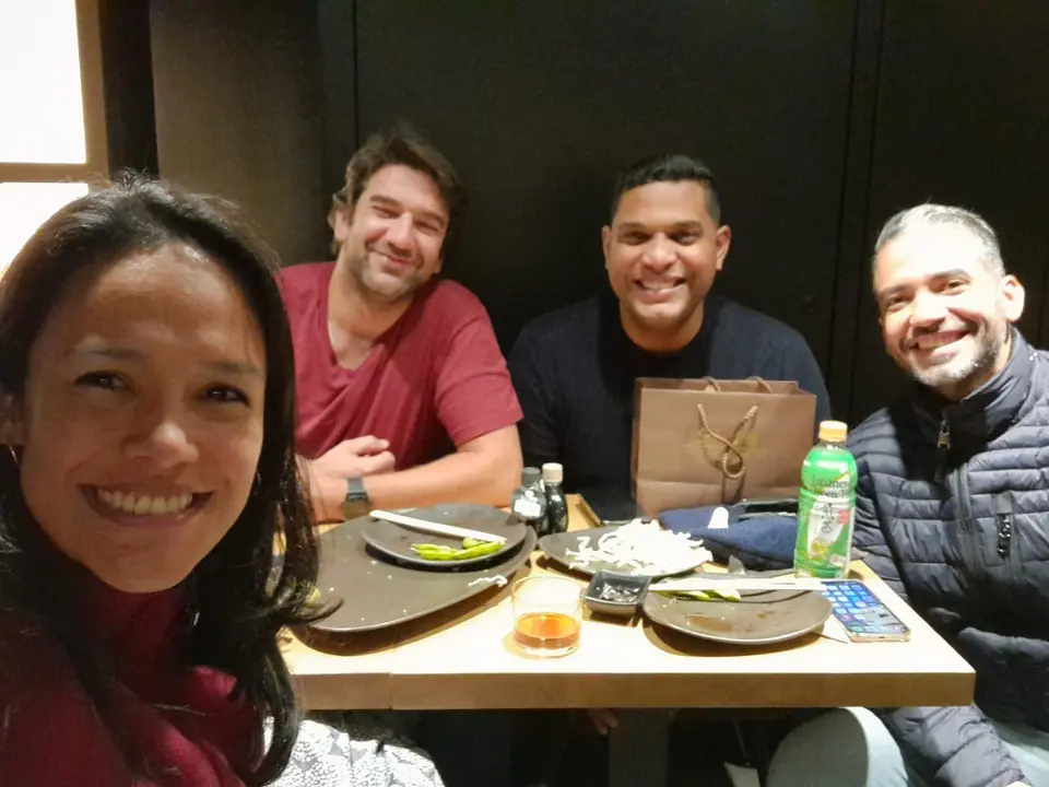 Alejandra Castillo and three men smiling at a restaurant table