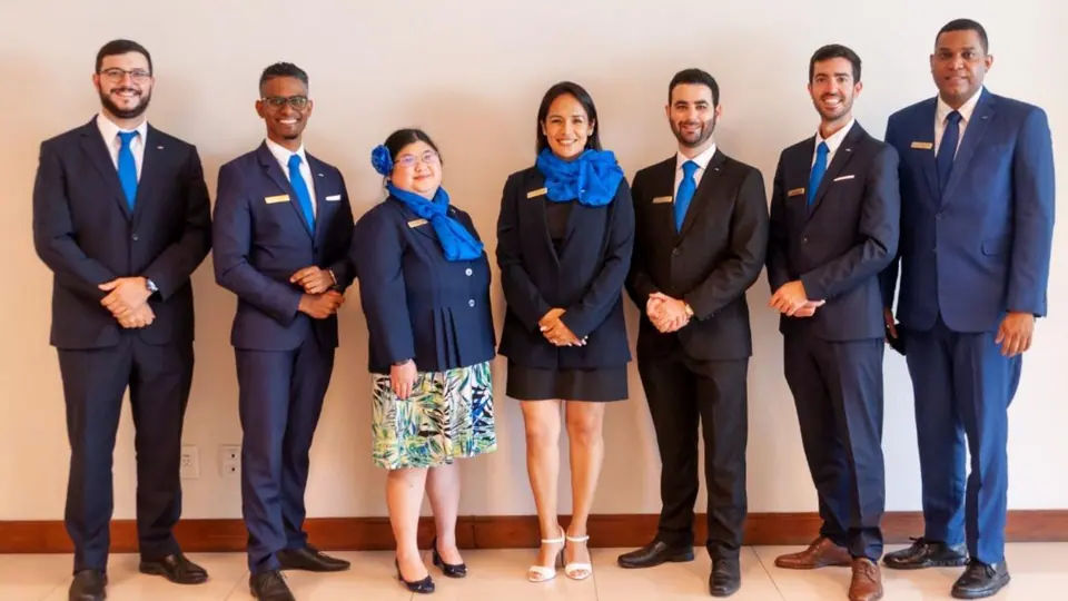 Seven JCI leaders in dark suits and blue accessories standing in a row