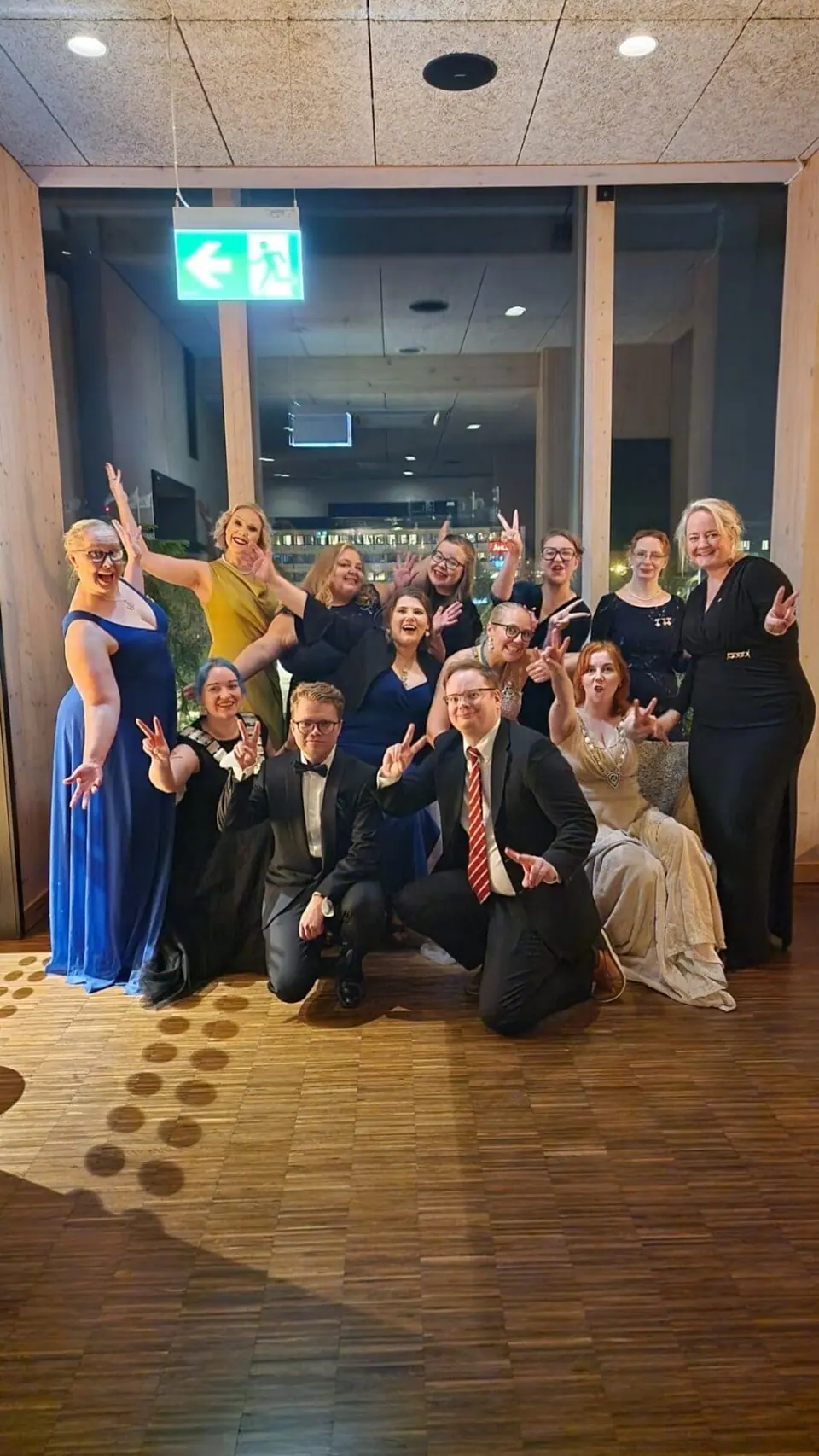 A group of people in evening wear gathered in a hall