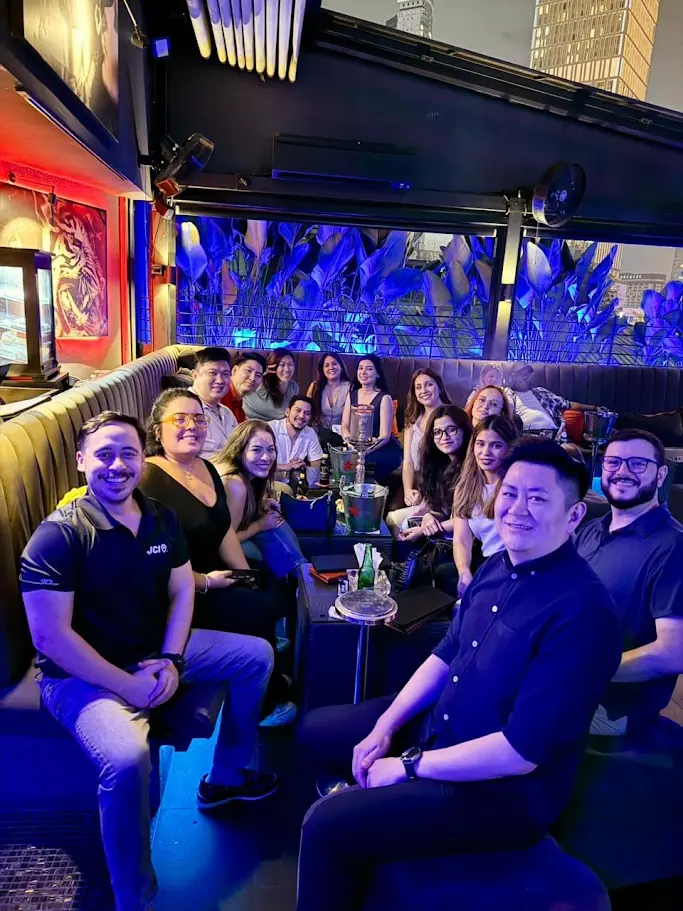 A group of colleagues at a table in a club with blue lighting