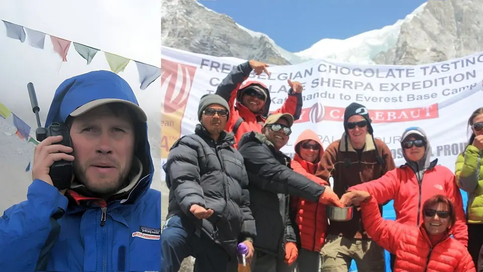 An expedition team in down jackets in front of a banner for a Belgian chocolate tasting at Everest base camp