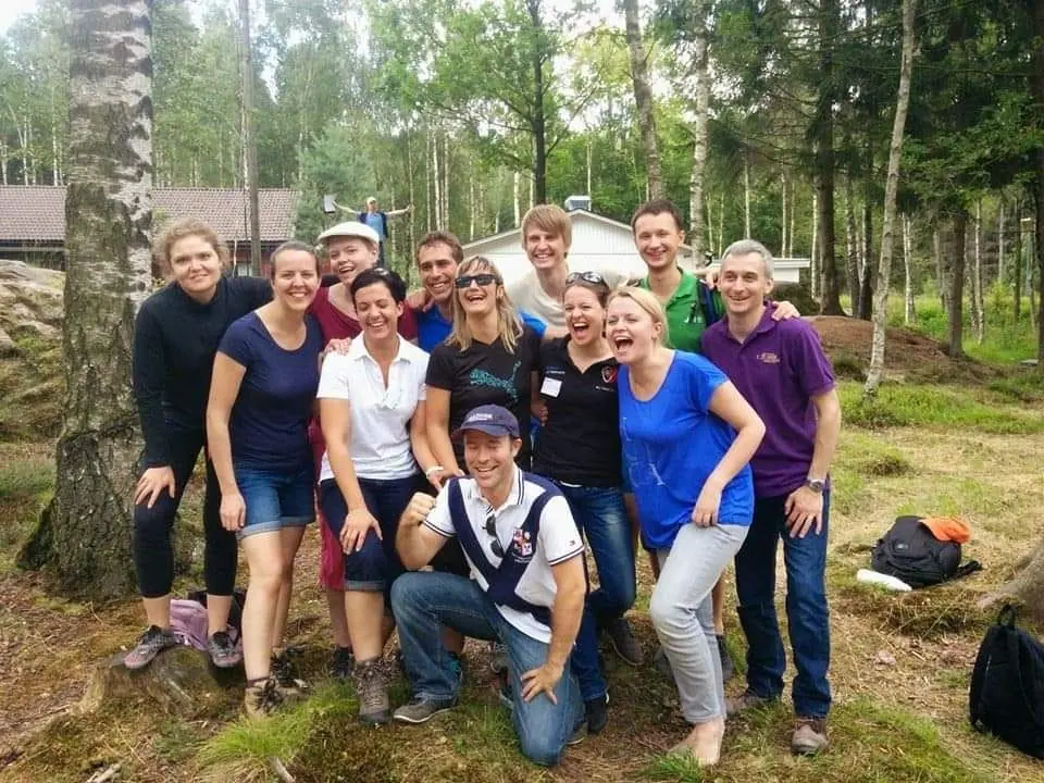 A group of volunteers posing together outdoors in a forest