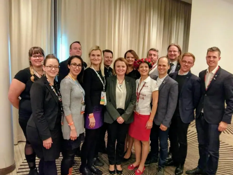A group of about a dozen JCI members posing together indoors