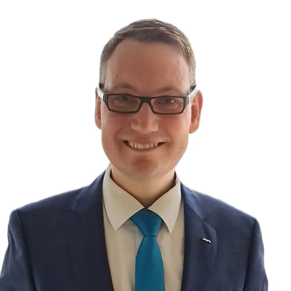 Portrait of Viktor Ómarsson in a navy suit and teal tie